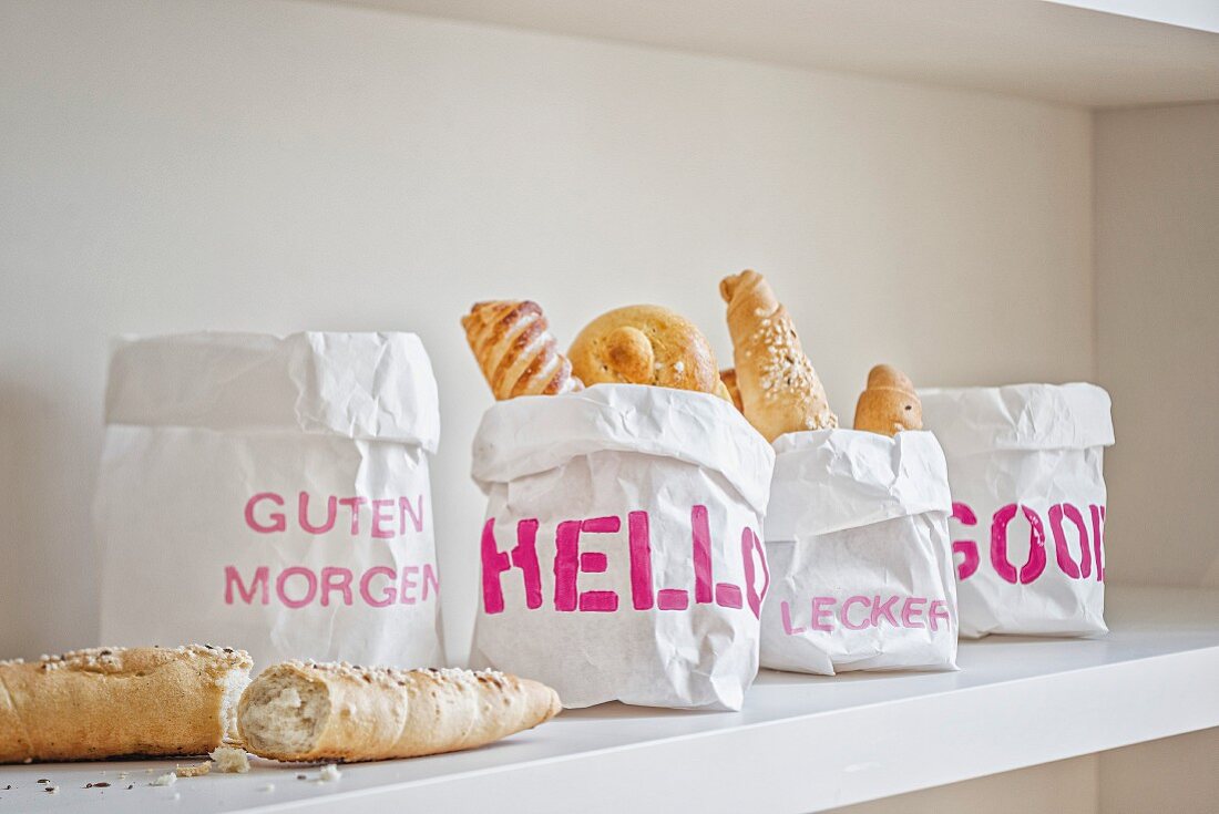 Paper bags printed with various stencilled mottos used as bread baskets
