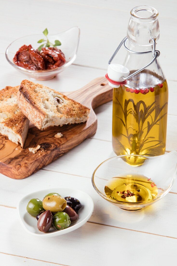 Antipasti: olives, dried tomatoes, olive oil and grilled bread (Italy)