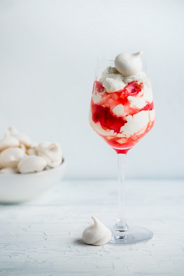 Sahnedessert mit Baisertupfen & Beerensauce in Stielglas