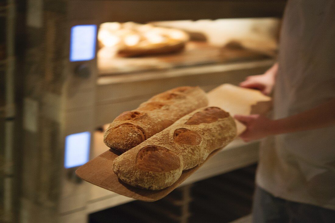 A baker with bread, London, England