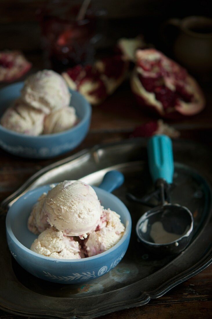 A bowl of vanilla ice cream next to an ice cream scoop