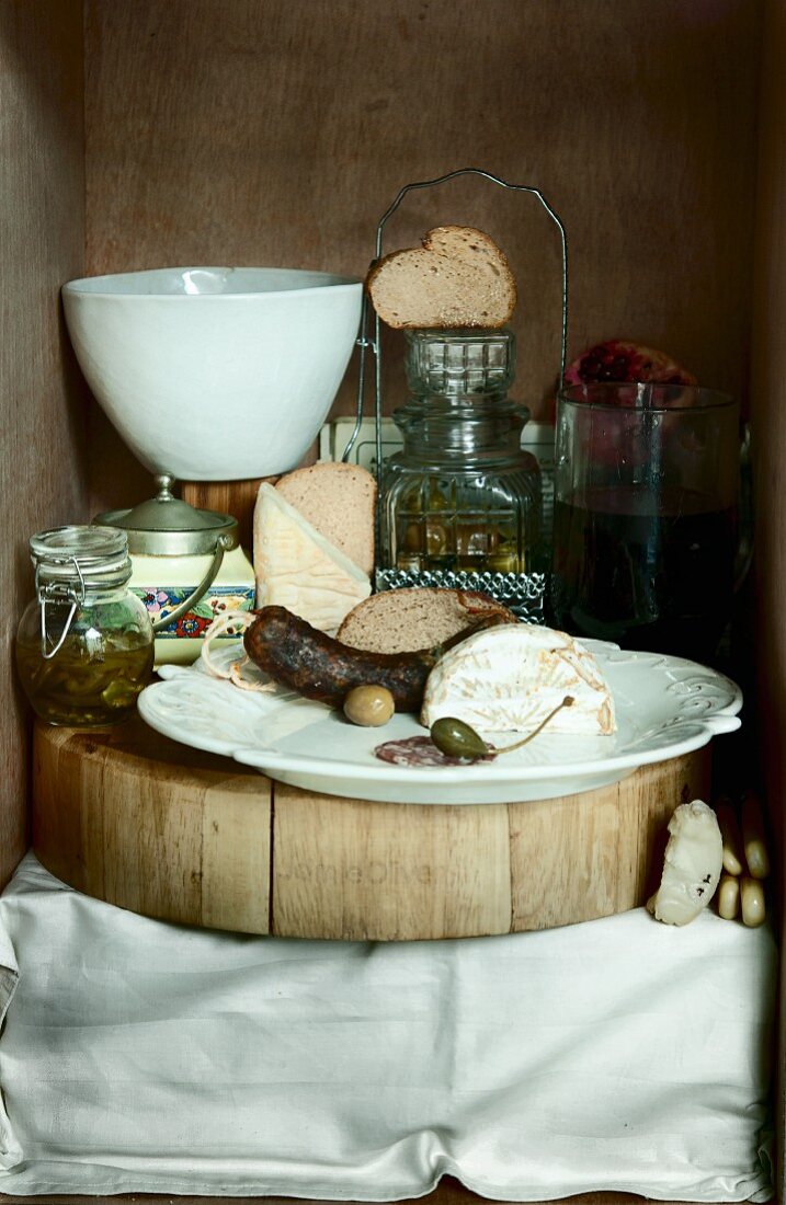A vintage supper featuring sausage, cheese, papers and olives
