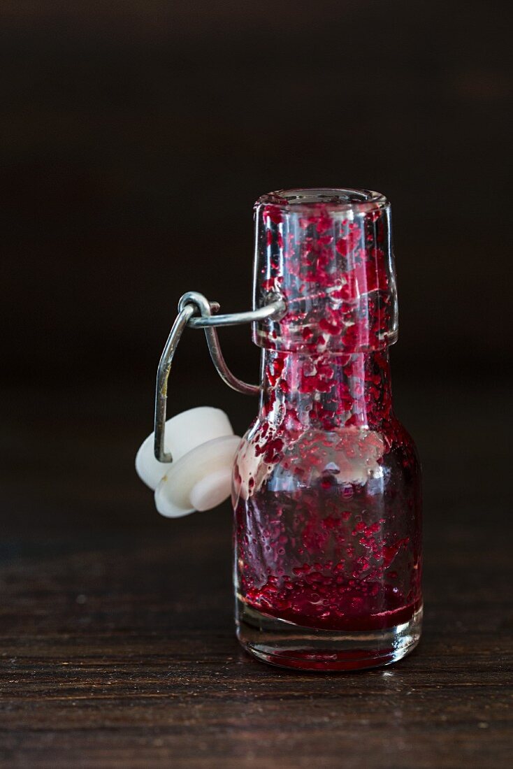 An empty bottle with the remains of beetroot smoothie