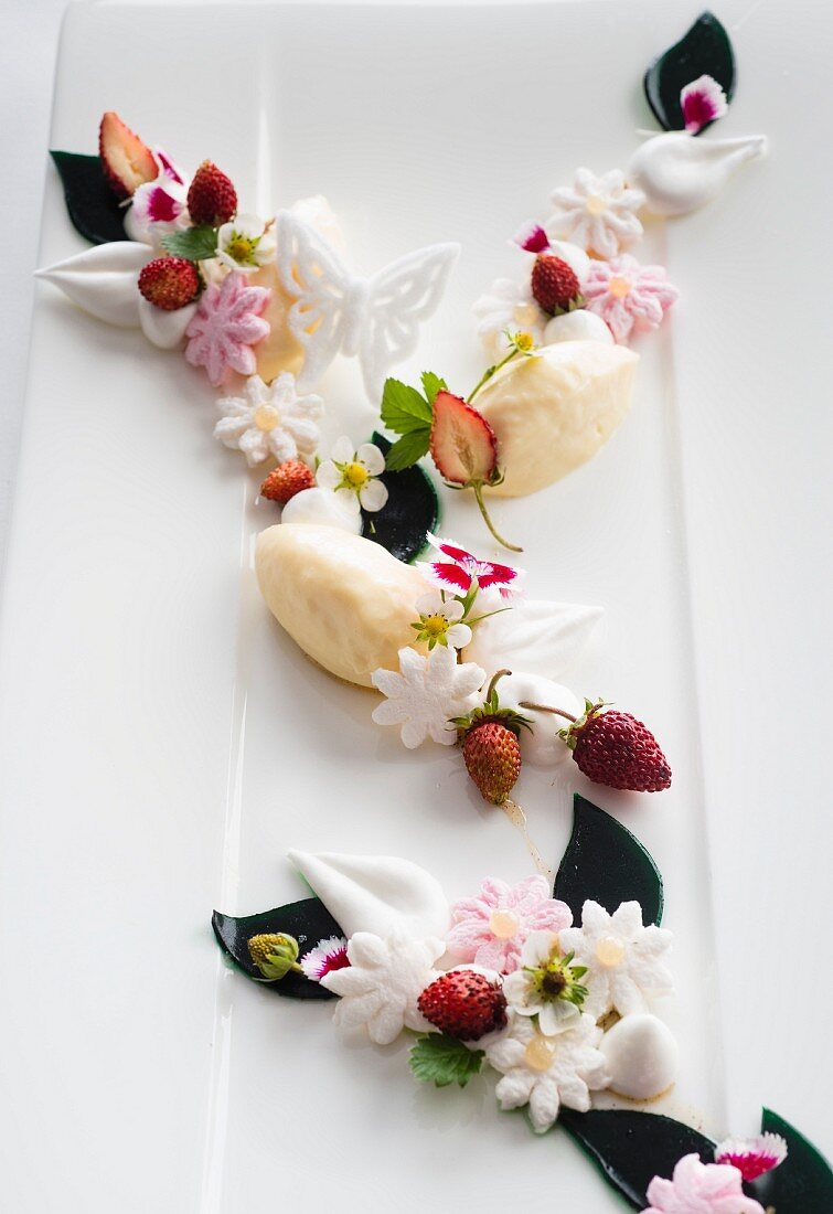 White chocolate mousse with wild strawberries and sugar flowers