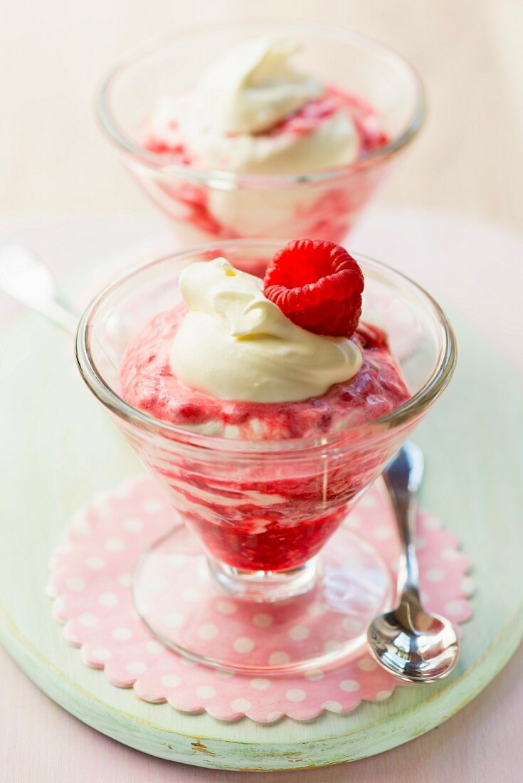 Raspberry ice cream sundaes with a dollop of cream