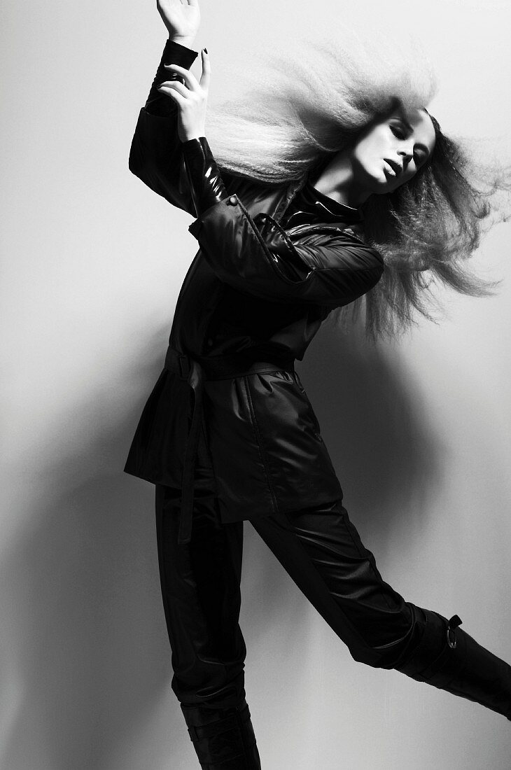 A young woman with crimped hair wearing a black outfit (black-and-white shot)