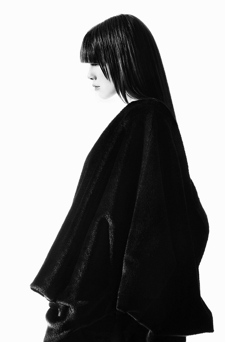 A young woman wearing a black cape (black and white shot)