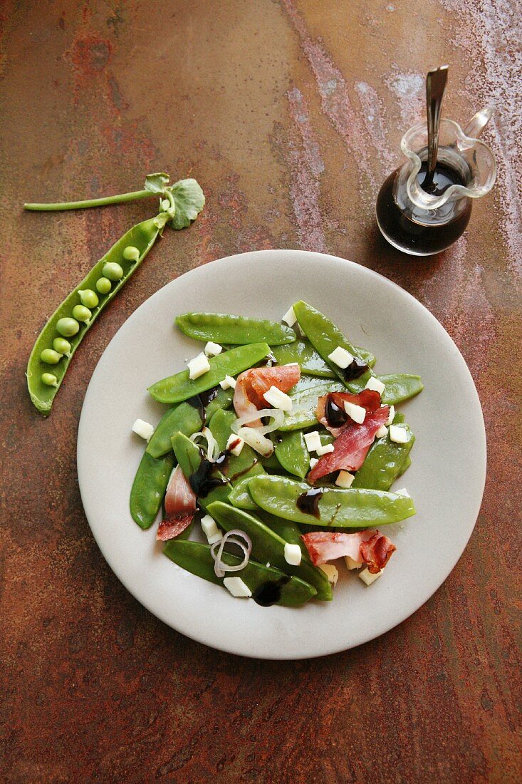 Mangetout salad with cubes of cheese, onion, bacon and balsamic vinegar