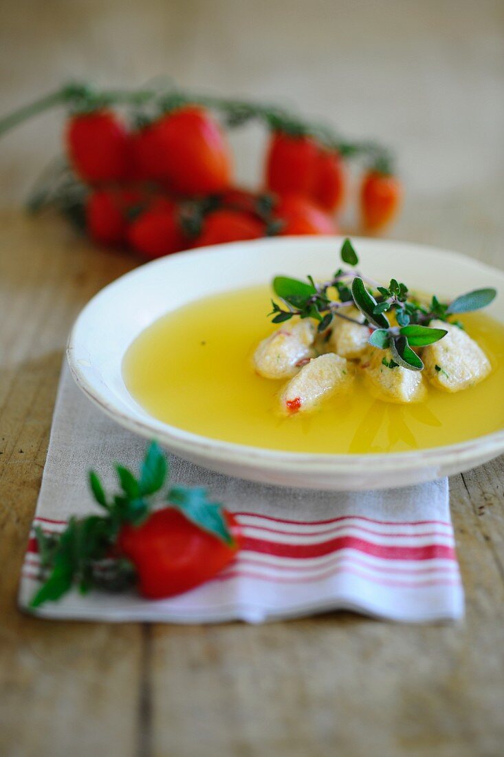 Clear tomato soup with semolina dumplings and fresh herbs