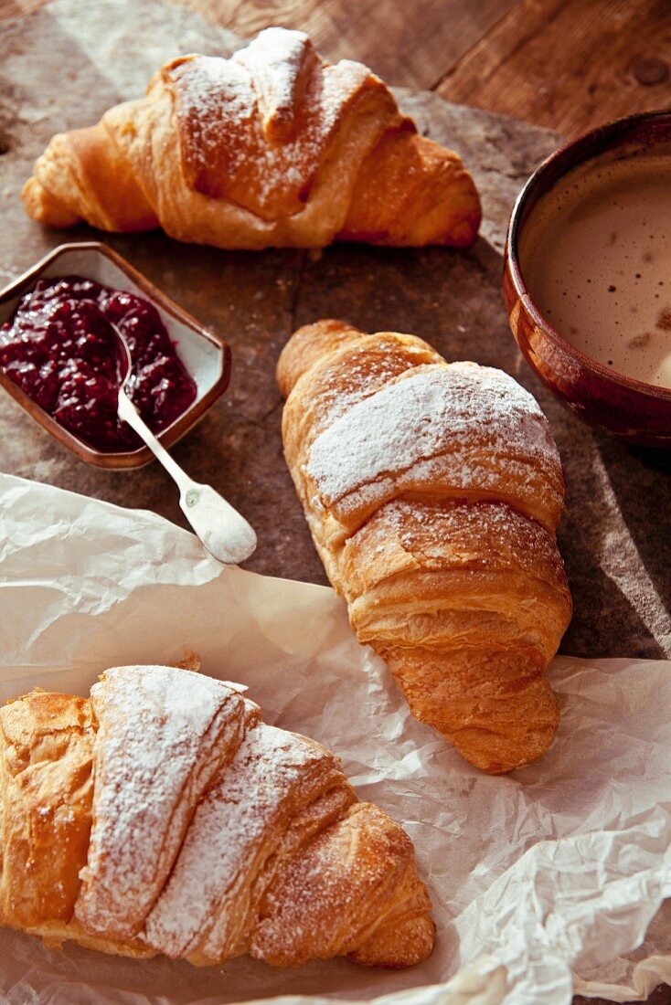 Butter croissants with raspberry jam and a cappuccino