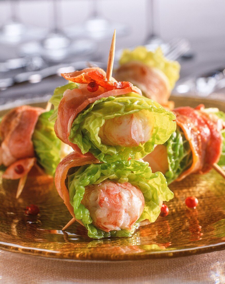 Scampi wrapped in bacon with lettuce leaves