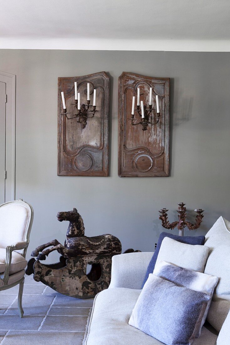 Arrangement of old shutters and candle sconces on wall