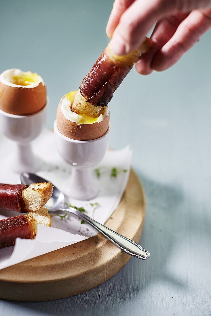Soft boiled eggs and bacon sticks for breakfast