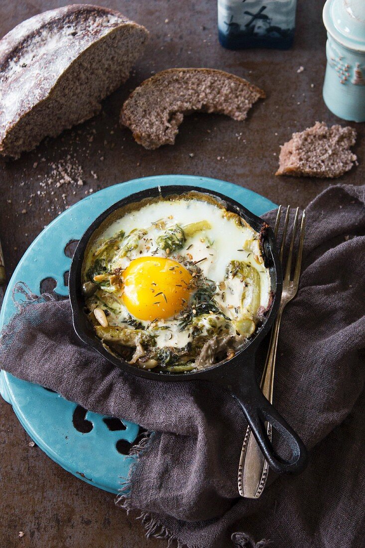 A fried egg with herbs and pine nuts