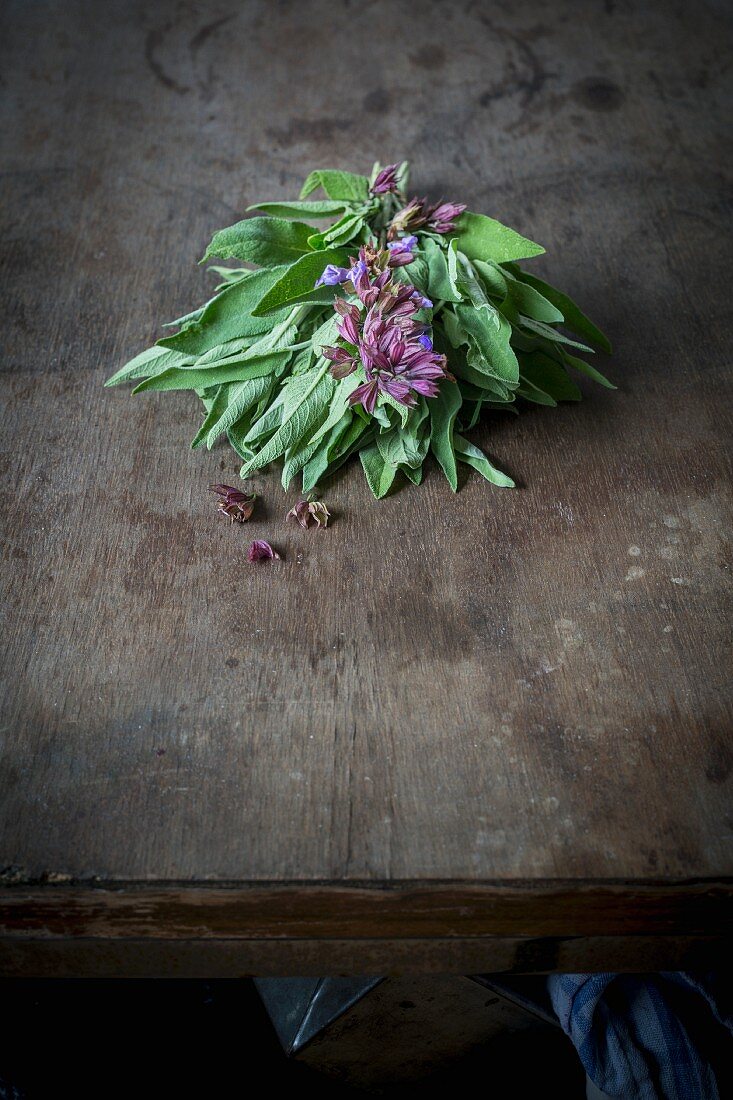 A bundle of flowering sage on a wooden table