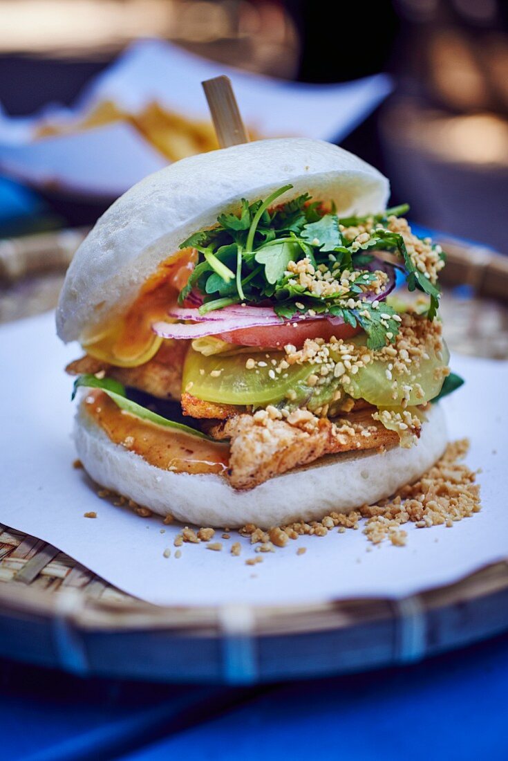 A chicken burger with avocado and radishes