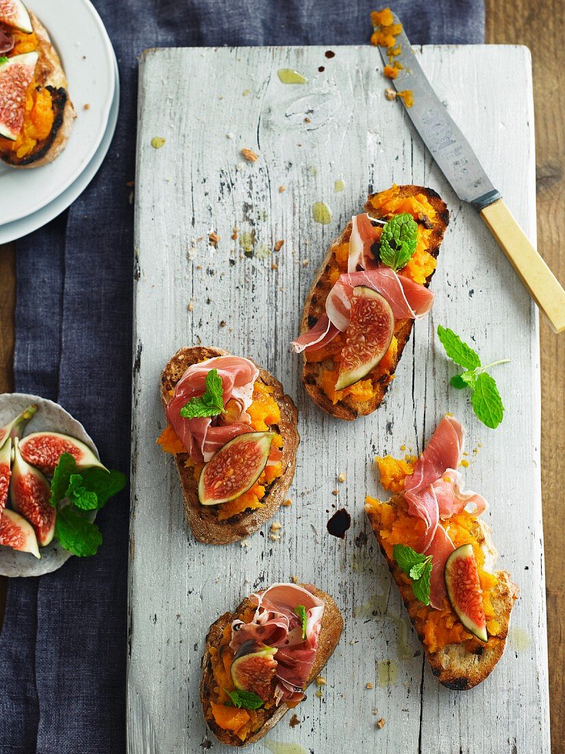 Crostini topped with pumpkin purée, Parma ham and figs