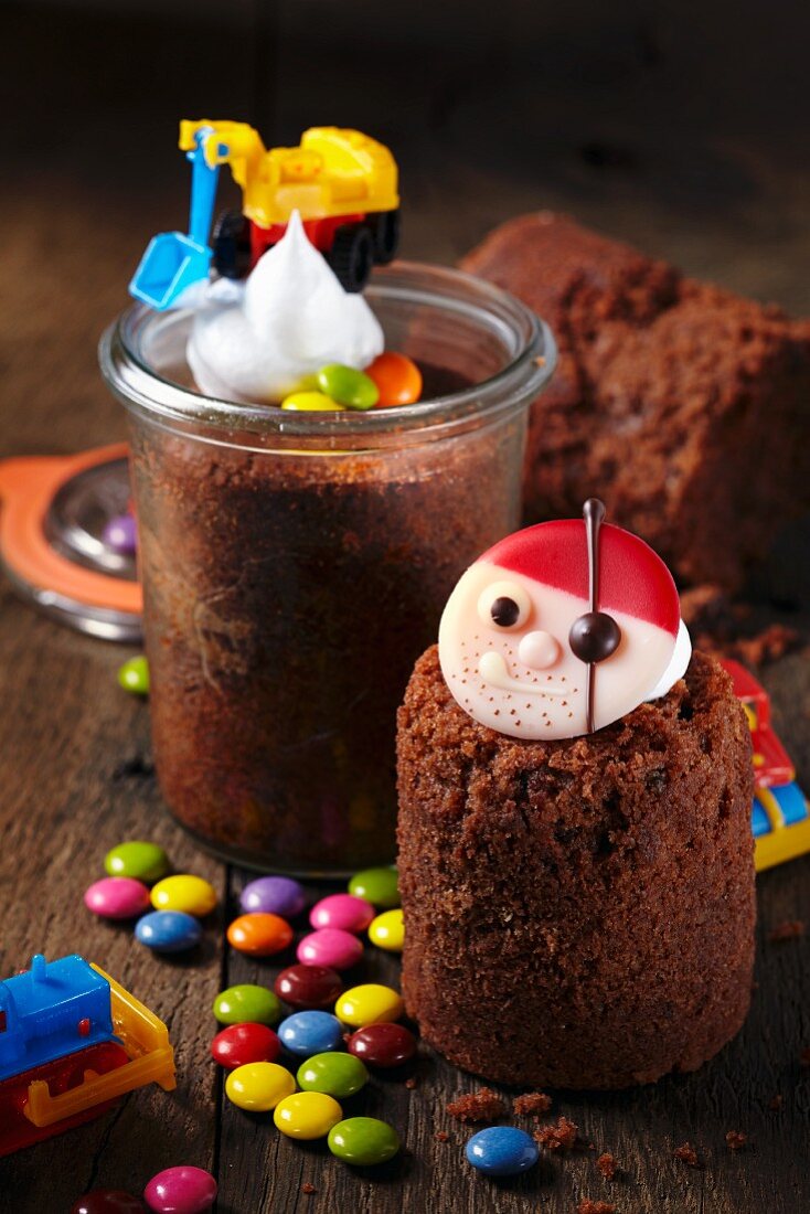 Chocolate trail mix cake baked in jars decorated with colourful chocolate beans and toys