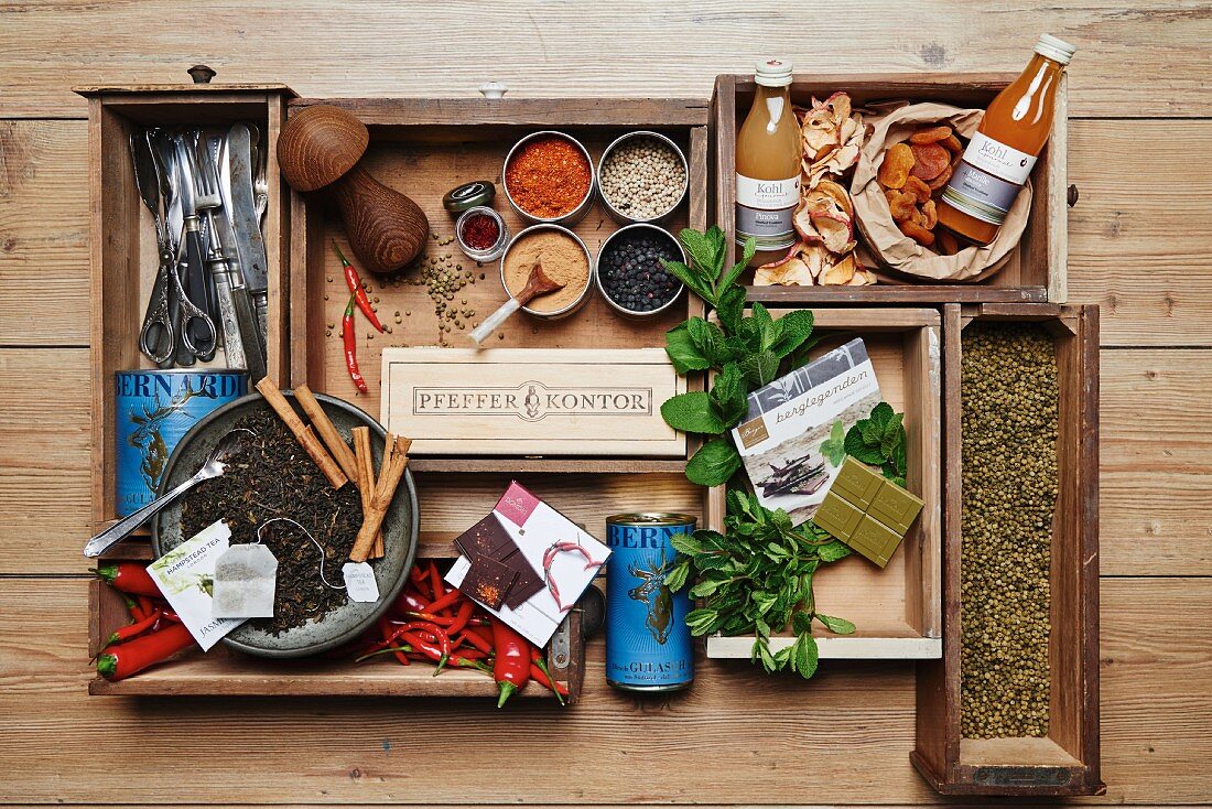 Various spices, herbs, dried fruit and kitchen utensils in wooden boxes