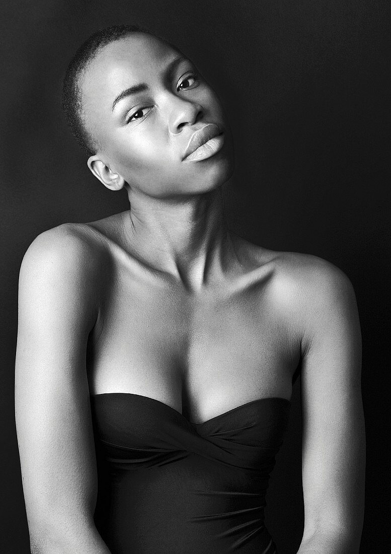 A dark-skinned woman wearing a shoulderless top (black-and-white shot)