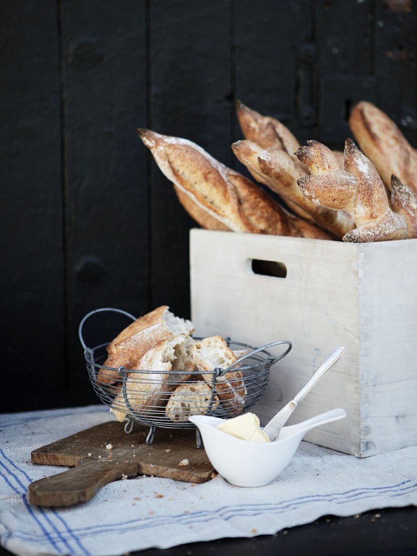 Fresh baguettes and a wooden crates and in a wire basket