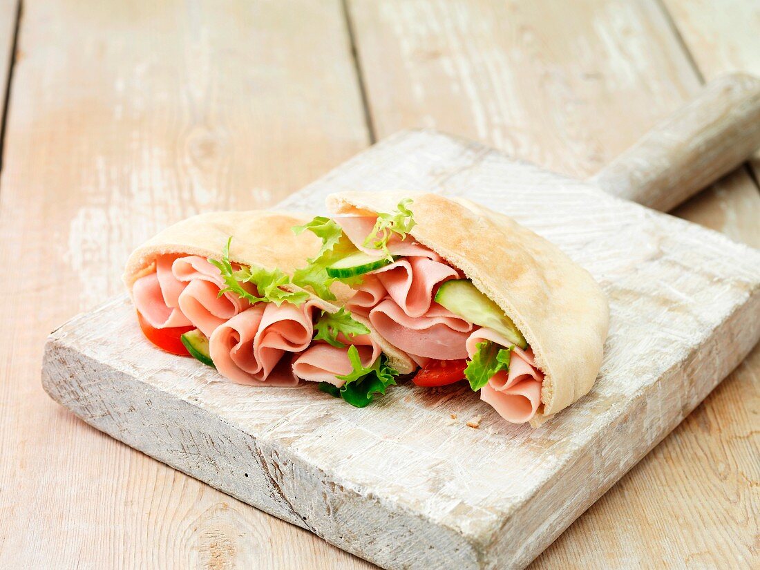 Pita bread filled with wafer thin ham, lettuce, tomatoes and cucumber