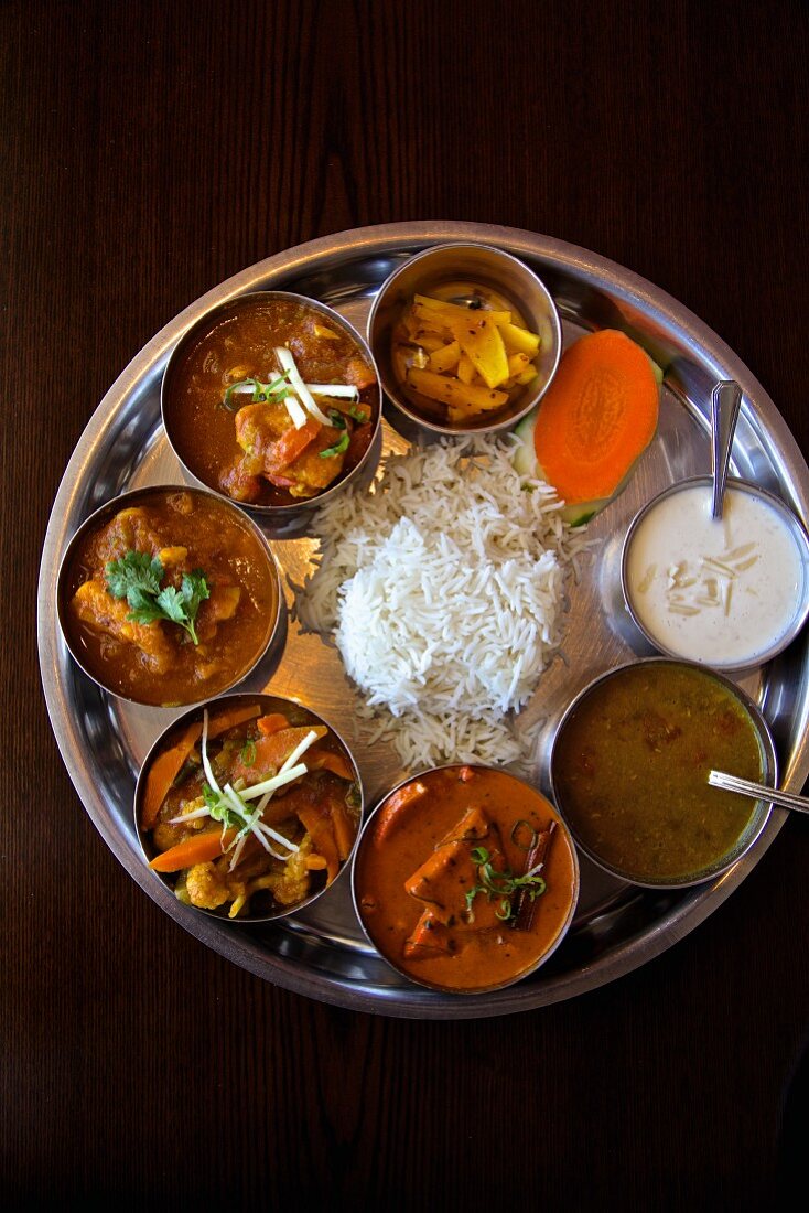 Thali mit Hähnchen, Lamm, Linsensuppe, Pickles, Currygemüse und Reis (Nepal)