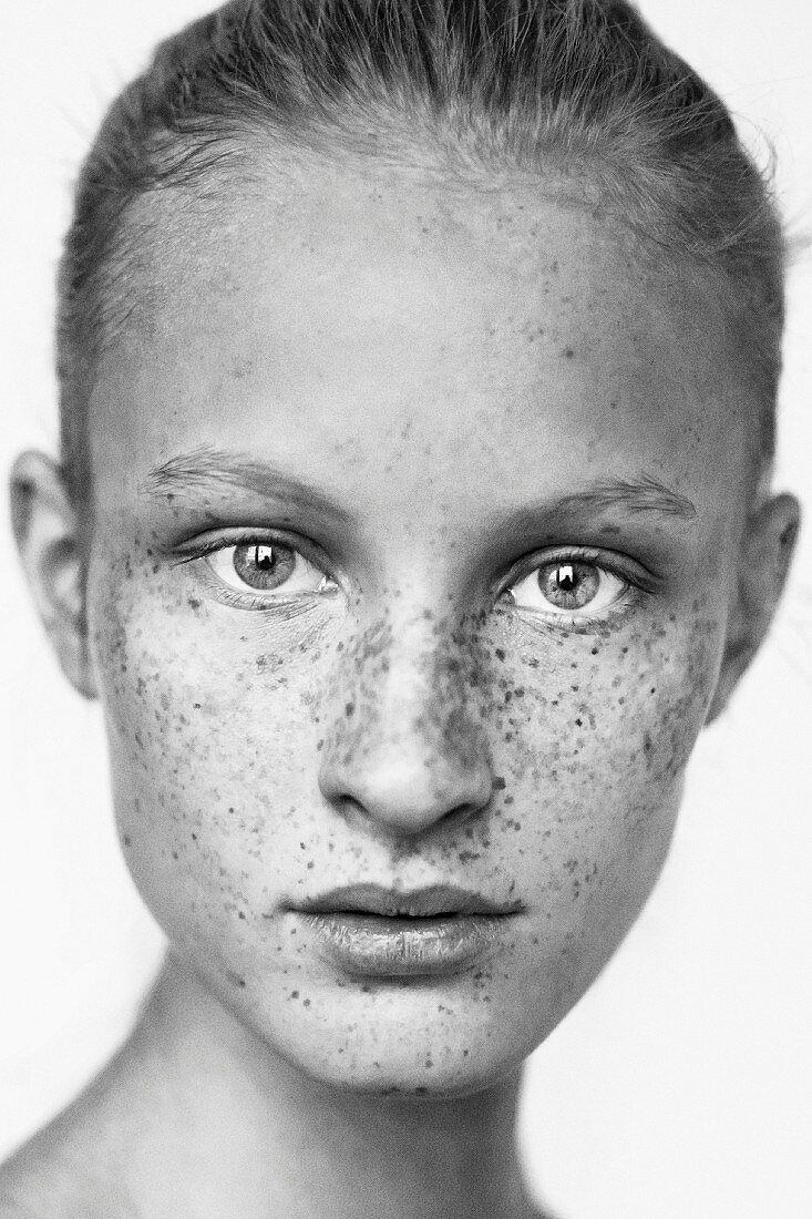 A young blonde woman with lots of freckles (black-and-white shot)