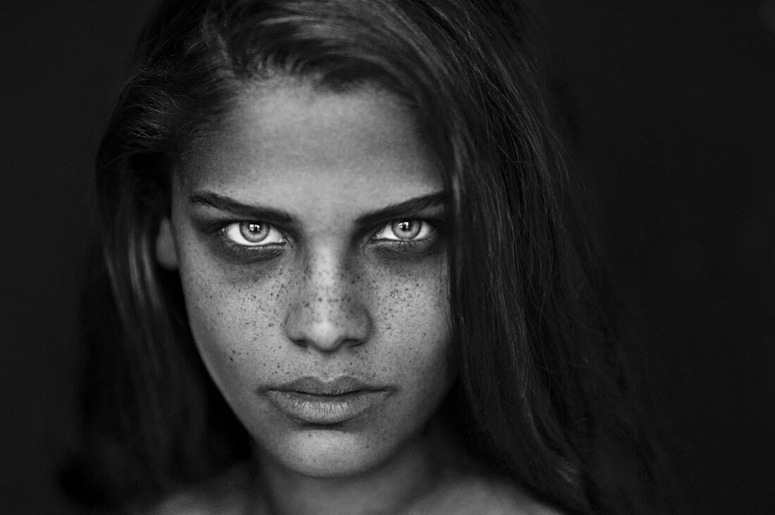 A young brunette woman with lots of freckles (black-and-white shot)