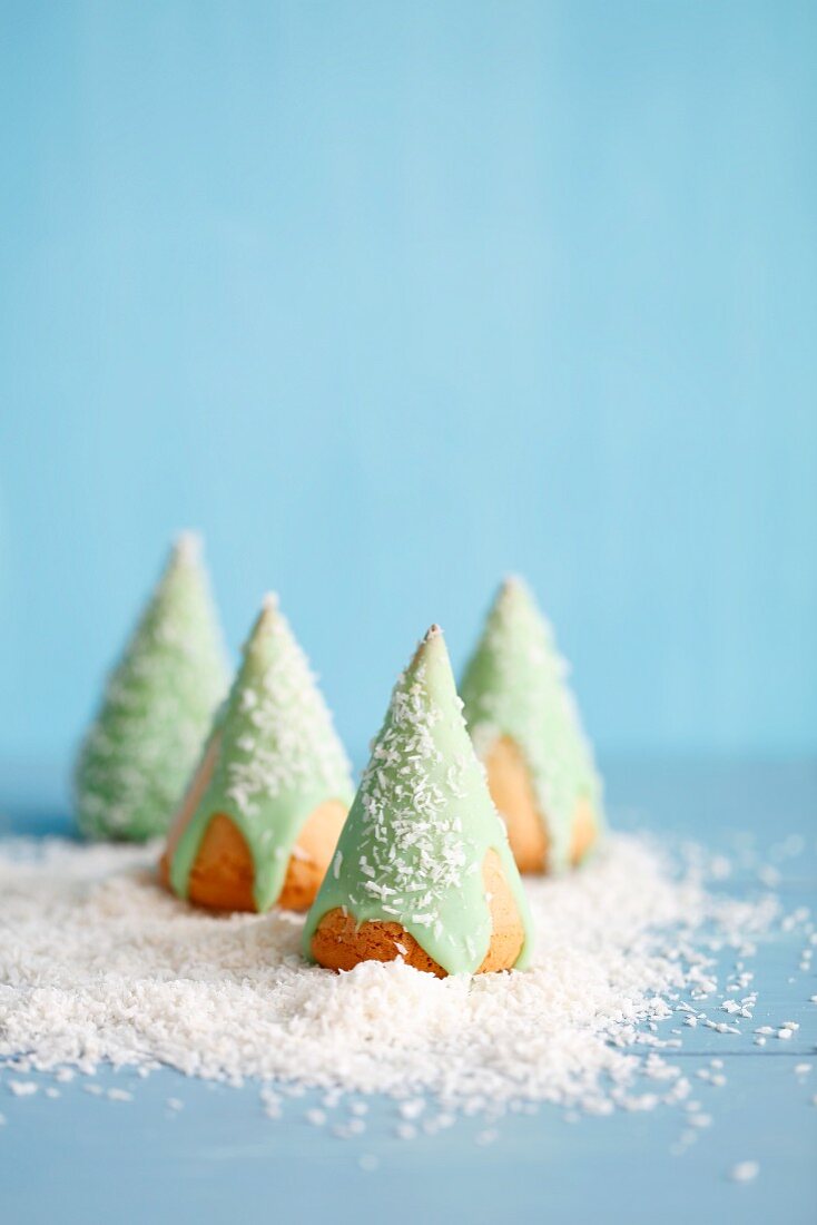 Biskuit-Weihnachtsbäume mit grünem Zuckerguss und Kokosraspeln