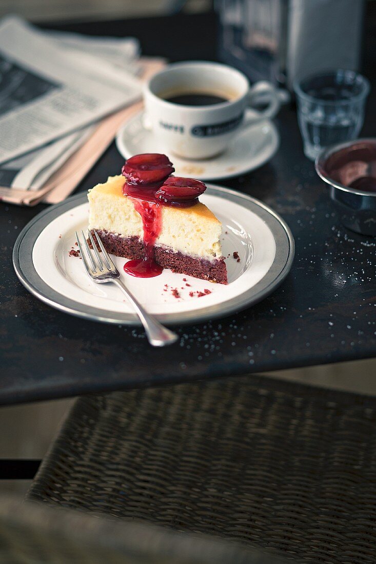 A slice of Red Velvet cheesecake with plums