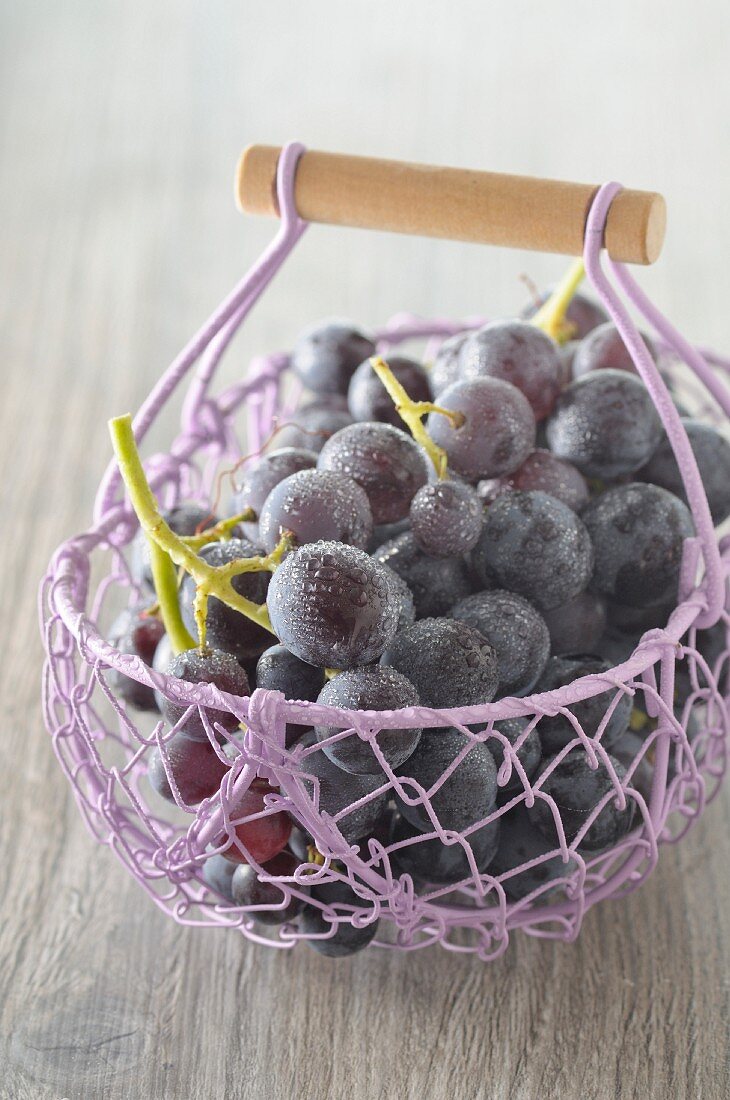 Freshly washed red grapes in a wire basket