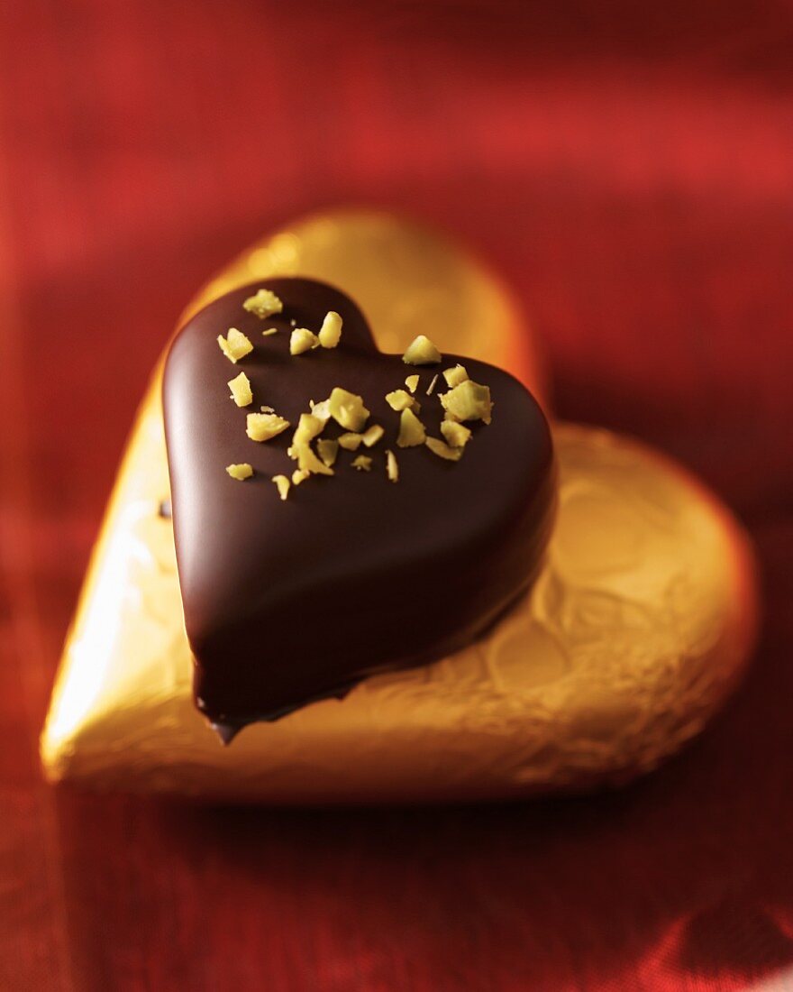 A marzipan heart coated in chocolates topped with pistachios