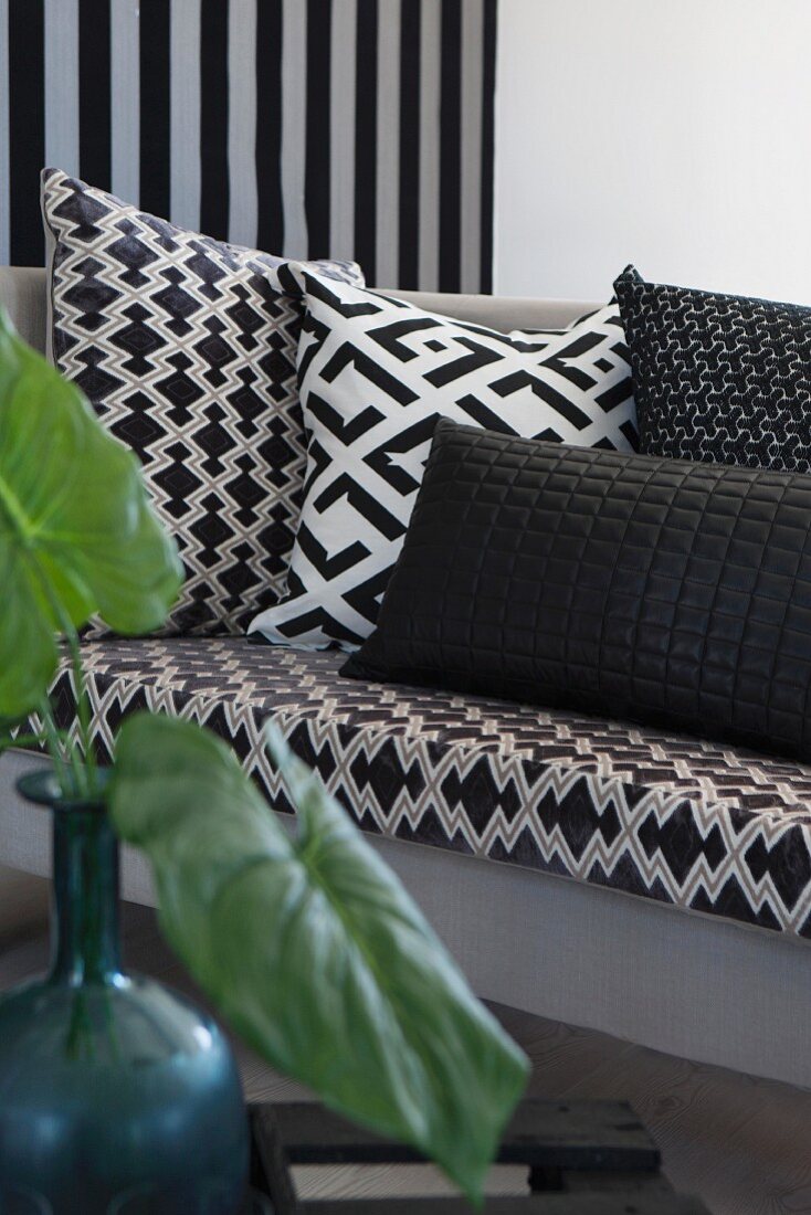 Scatter cushions with geometric, black and white patterns on sofa