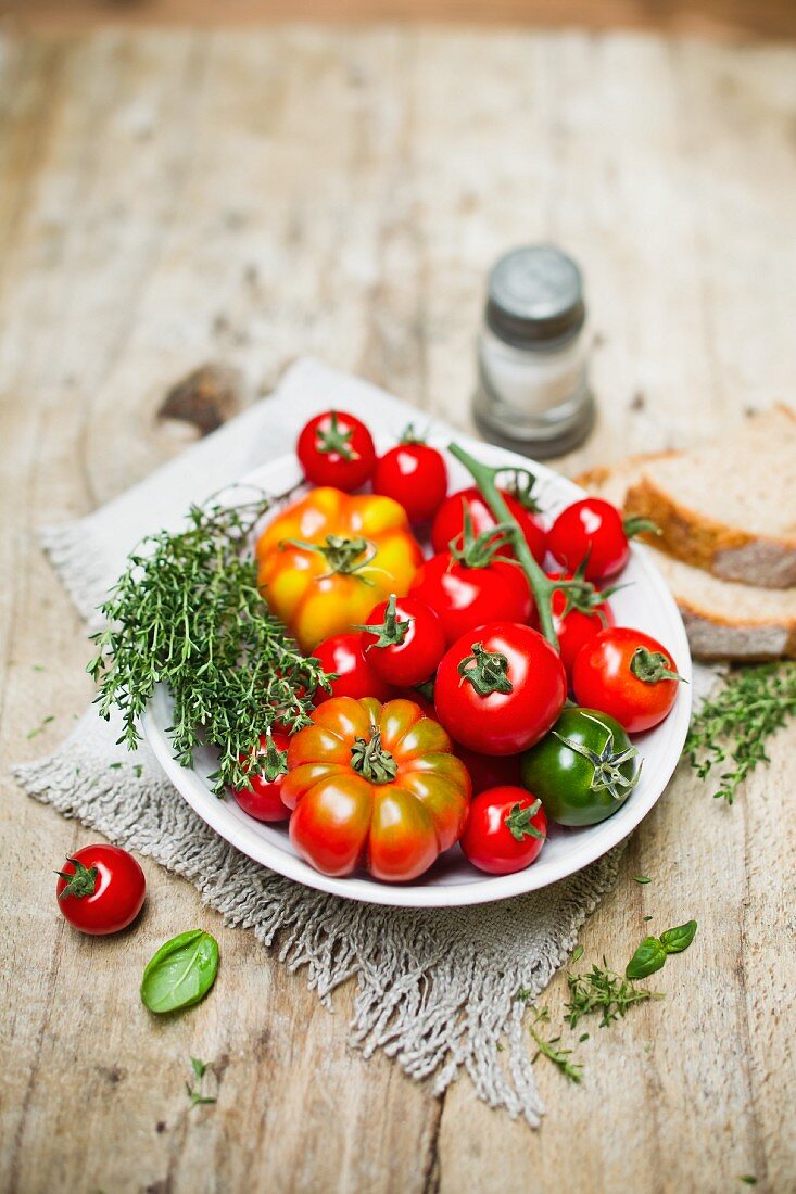 Various tomatoes in a bowl with thyme
