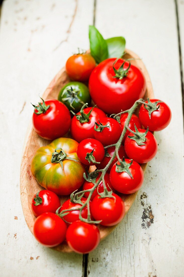 Various tomatoes in a wooden dish