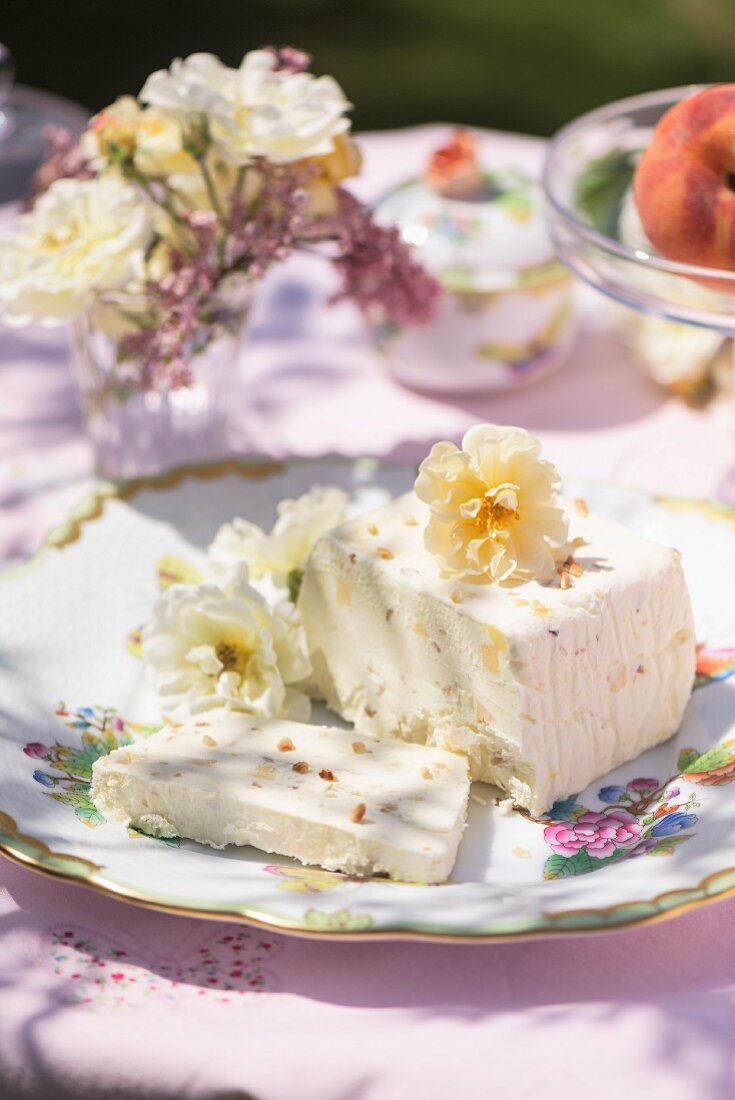 Eisdessert mit Blumendeko auf Gartentisch