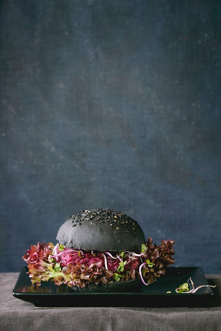 A homemade veggie burger with beetroot, sprouts, mushrooms and lettuce