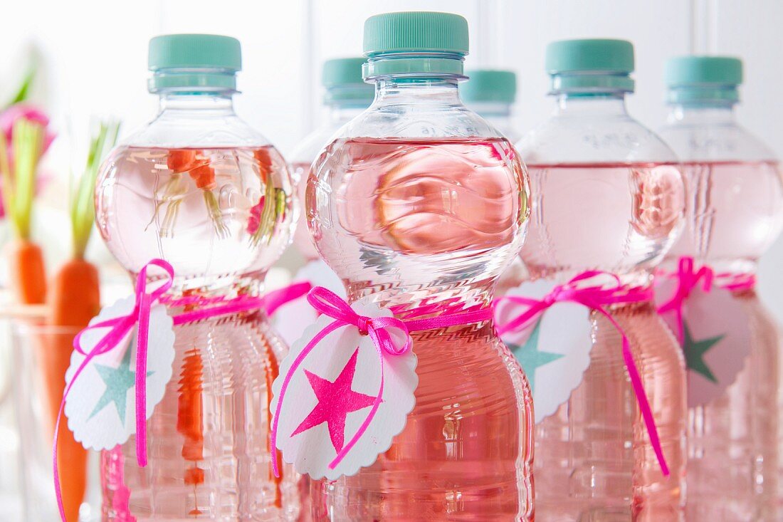 Bottles of water with self-printed labels and ribbons