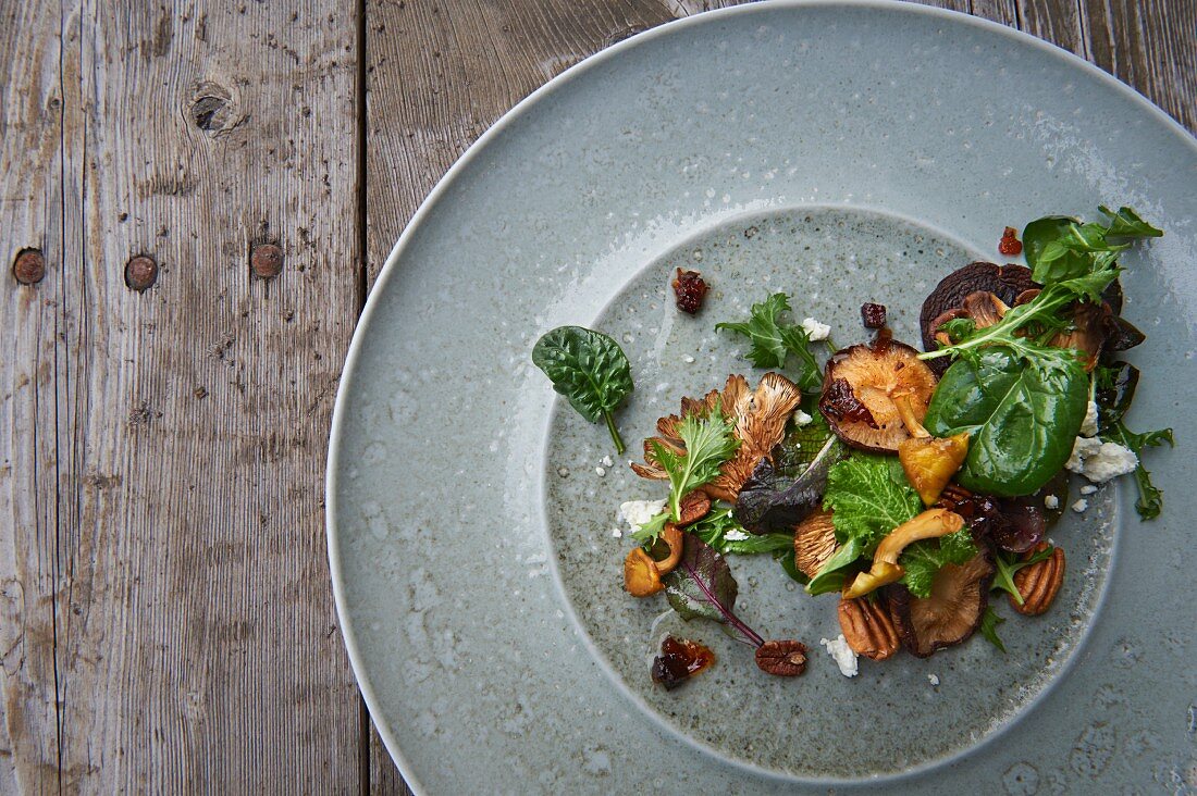 Waldpilzsalat mit Wintergemüse, Ziegenkäse, Pekannüssen und Speckvinaigrette