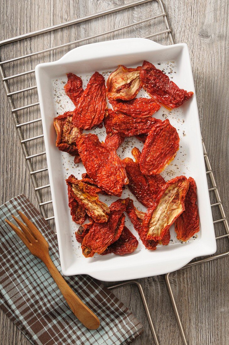 Dried tomatoes with salt and ground black pepper (seen from above)