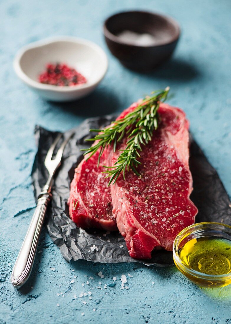 Raw beef steaks with rosemary and spices