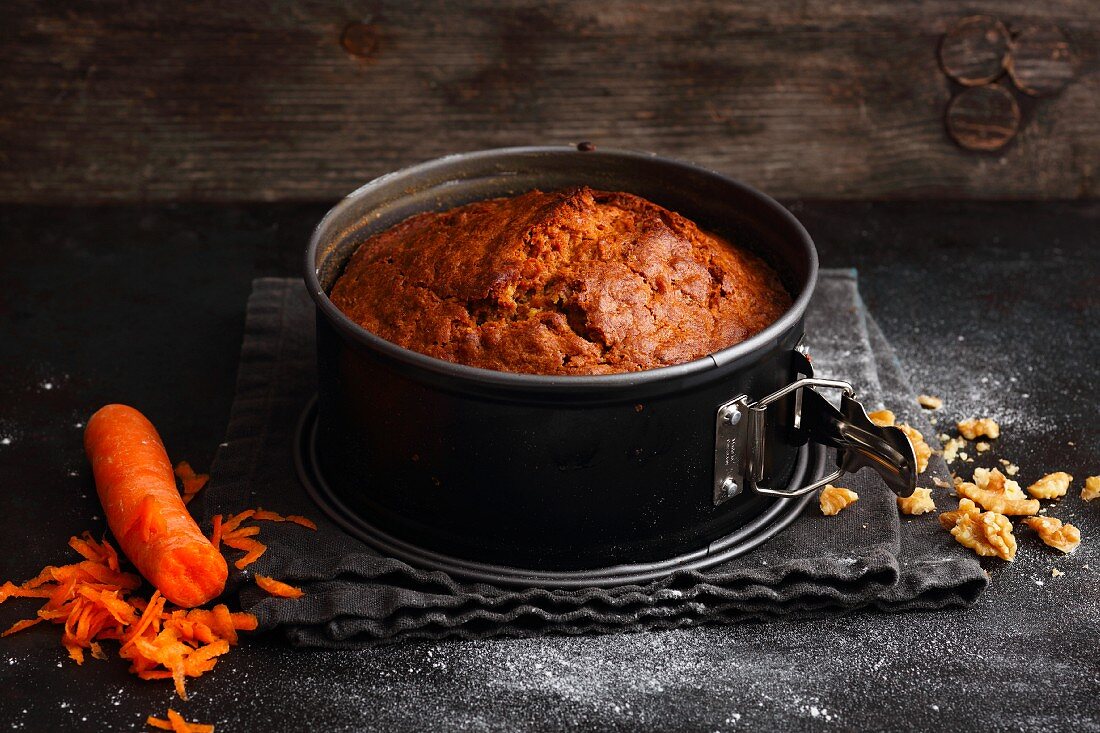 Classic carrot cake with walnuts in a baking tin