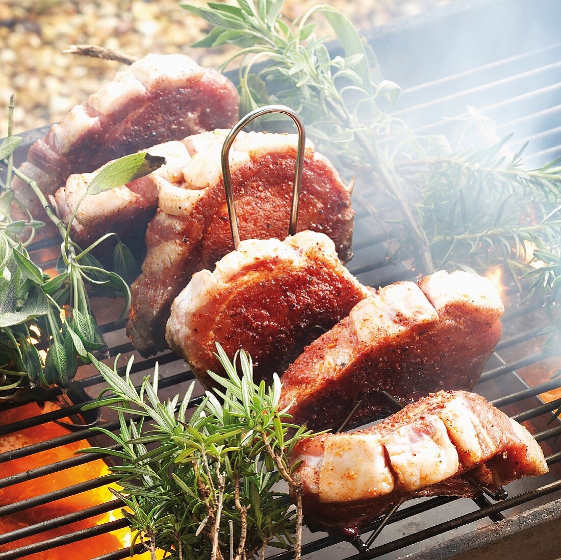 Pork chops with rosemary and sage on a barbecue