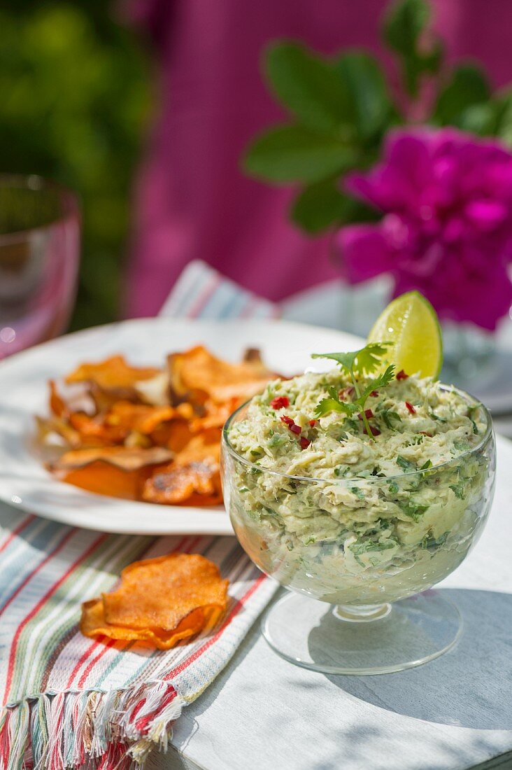 Mackerel and avocado cream with root vegetable crisps on a table outside