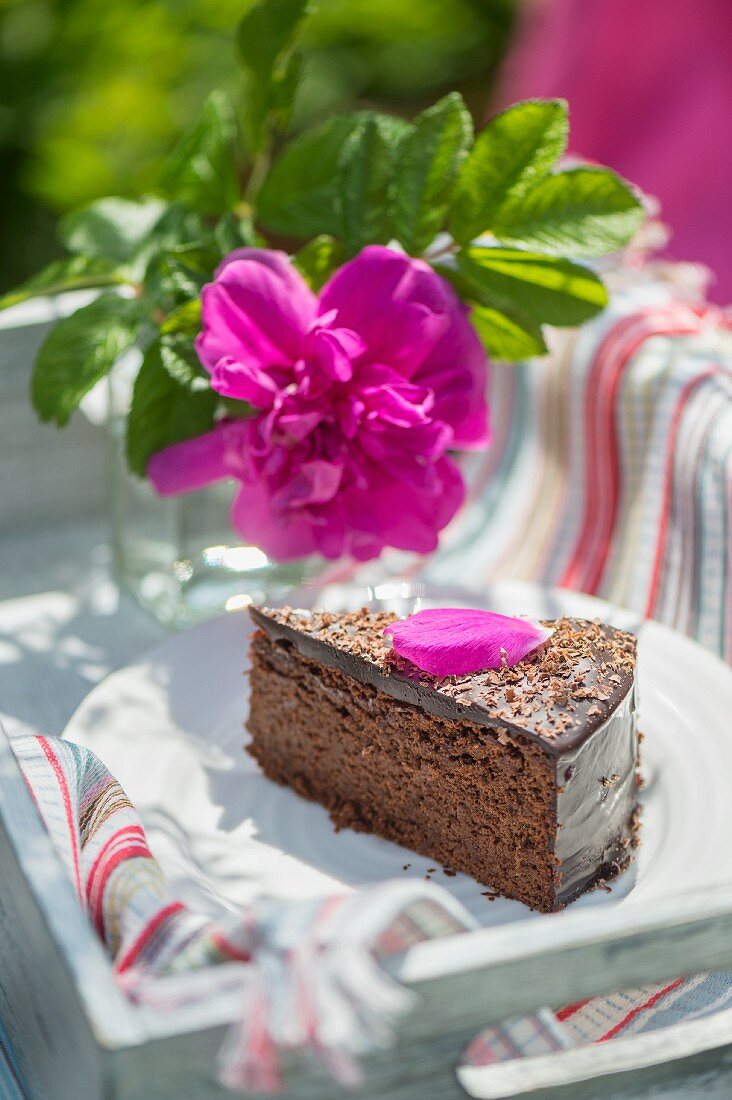 A slice of chocolate cake with cherry liqueur on a table outside
