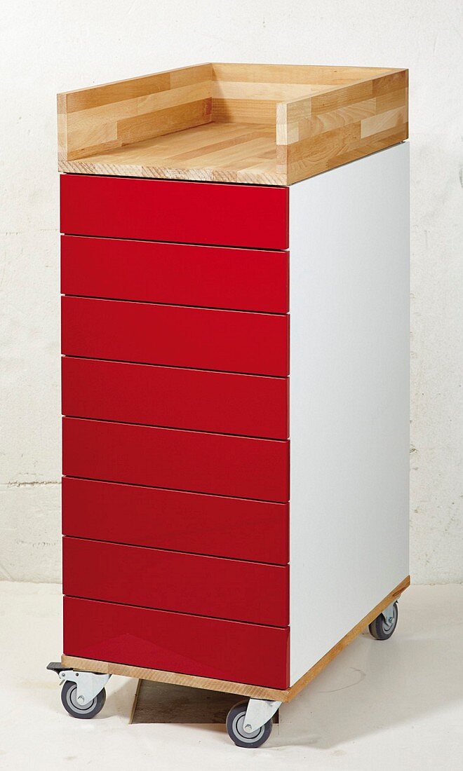 Renovated chest of drawers with red fronts on castors