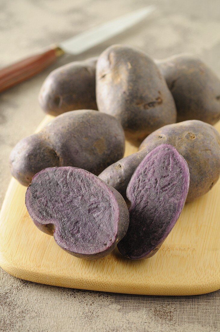 Purple potatoes on a wooden board