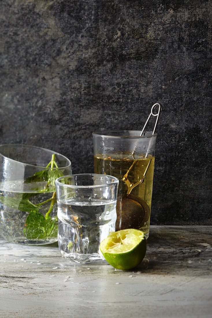 Water with lime, fresh mint and tea in a tea infuser