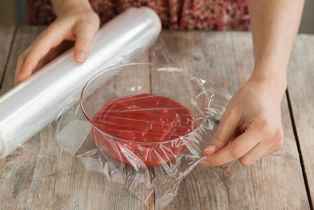 A bowl of macaroon filling being covered with clingfilm